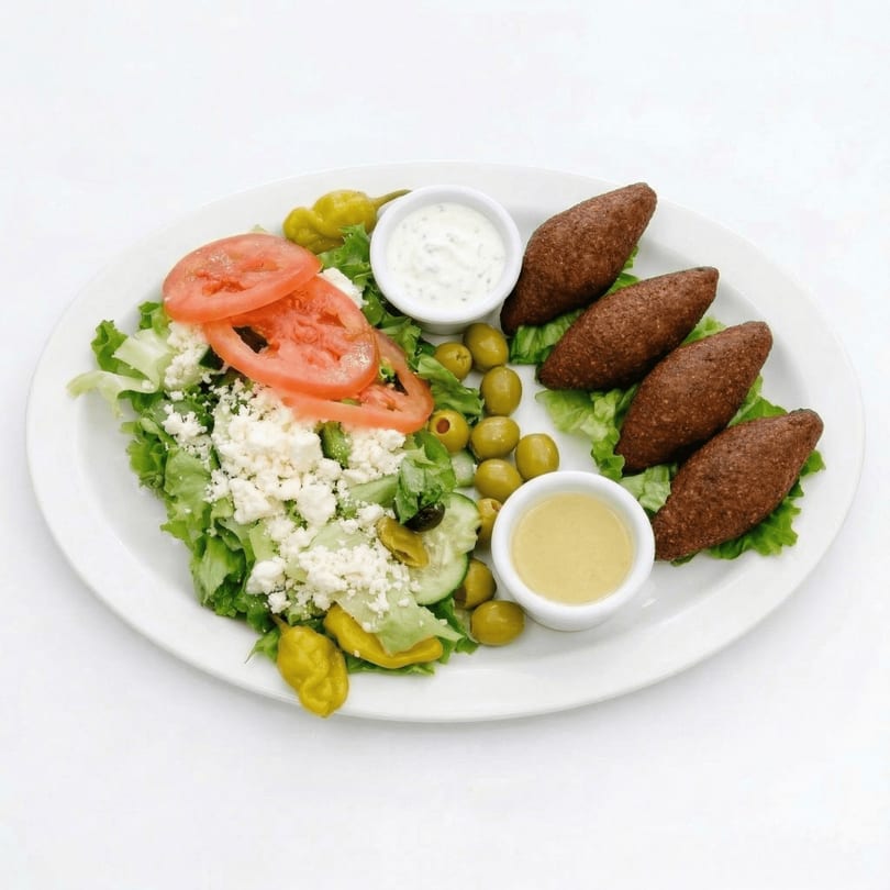 A white plate with a salad, kibbeh, olives, and two dipping sauces.